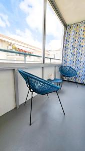 a balcony with a blue chair and a table at CoeurDeSable - Appartement T3 Hyper Centre Arcachon - Parking in Arcachon +20 photos