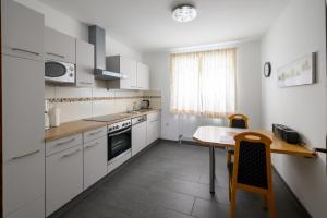 a kitchen with white cabinets and a table and a dining room at Am Randersberg - Wohnung Nr 3 in Grossgmain