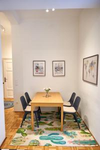 a dining room with a table and chairs on a rug at Renovated & Cozy - Close to Museumsquartier in Vienna