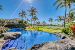 ワイコロアにあるWaikoloa Fairway Villas #F3のヤシの木と家のスイミングプール
