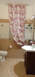 een badkamer met een wastafel, een toilet en een gordijn bij La dimora dei Mori Gela in Gela