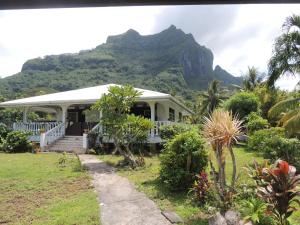 una casa blanca con una montaña en el fondo en Chez Mimi et Daniel en Bora Bora