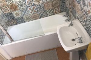 a bathroom with a sink and a bath tub at Cheerful two bedroom cottage in the Forest of Dean in Lydbrook