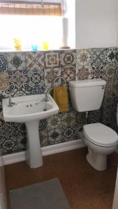 a bathroom with a toilet and a sink at Cheerful two bedroom cottage in the Forest of Dean in Lydbrook