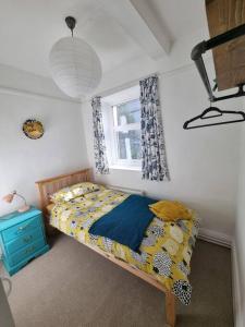 Habitación pequeña con cama y ventana en Cheerful two bedroom cottage in the Forest of Dean, en Lydbrook