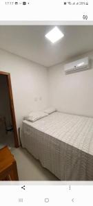 a bedroom with a bed with a white bedspread at Vila Alicia Flecheiras in Flecheiras