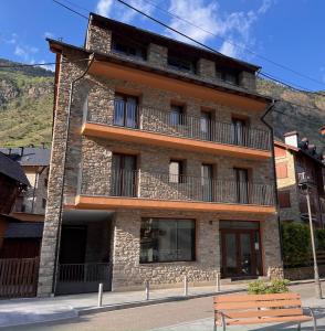 a building with a bench in front of it at Espot Cowork & Apartments in Espot