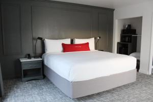 Schlafzimmer mit einem großen weißen Bett und einem roten Kissen in der Unterkunft Vinland Hotel and Lounge in Solvang