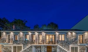 une maison en pierre éclairée la nuit dans l'établissement DreamStone Residence, à Skala Prinou