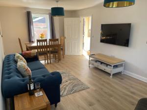 sala de estar con sofá azul y mesa en Hidden Hideout, Cromer, Norfolk, en Cromer