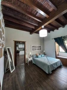 ein Schlafzimmer mit einem Bett und einem Holzboden in der Unterkunft Casita Aljibe in San Miguel de Abona