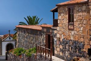 een oud stenen gebouw met een veranda en een deur bij Casita Aljibe in San Miguel de Abona