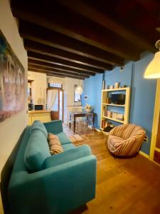 - un salon avec un canapé bleu et une table dans l'établissement Casa Torrazzo, à Pisogne