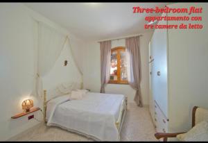 a white bedroom with a bed and a window at Villa le Arcate in Furore