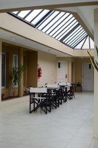 a cafeteria with tables and chairs under a skylight at Hotel Suite & Spa Verdesolaro in Villa Elisa