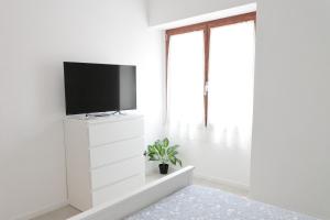 salon z telewizorem na białej ścianie w obiekcie Sorso per passione w mieście Sorso