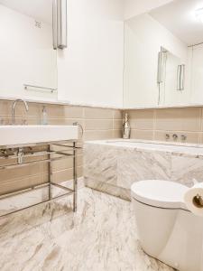 a bathroom with a sink and a toilet and a tub at Quiet Luxury Apartment Powiśle - Centrum Kopernik in Warsaw