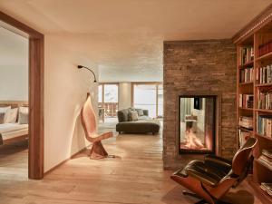 a living room with a fireplace and a couch at Firefly Luxury Suites in Zermatt