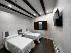 Cette chambre comprend 2 lits et une télévision à écran plat. dans l'établissement Casa Rural EL CAMPICO, à Puerto de Mazarrón
