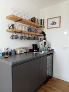 a kitchen with a black counter and shelves at Flotnar Hús - Ensuite Rooms in Keiss