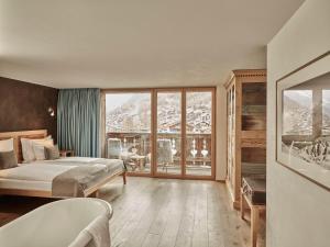 a bedroom with a bed and a view of a mountain at Firefly Luxury Suites in Zermatt