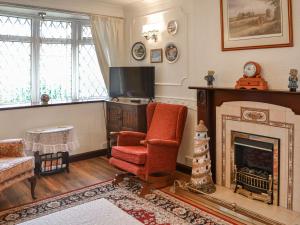 a living room with a fireplace and a chair and a tv at Josies Den in Bridlington