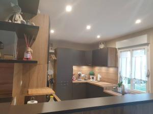 Una cocina con gabinetes de madera y encimera. en Cosy maison Honfleur 2 chambres parking jardin et jacuzzi, en La Rivière Saint Sauveur