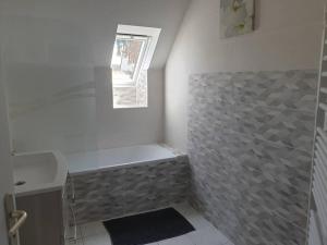 Un baño con bañera y ventana. en Cosy maison Honfleur 2 chambres parking jardin et jacuzzi, en La Rivière Saint Sauveur 8 fotos más