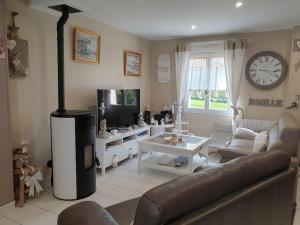 Una sala de estar con un sofá y un televisor. en Cosy maison Honfleur 2 chambres parking jardin et jacuzzi, en La Rivière Saint Sauveur