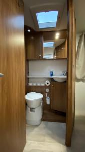 a small bathroom with a toilet and a sink at Camper in Sandnes