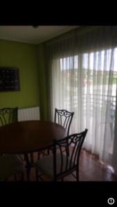 uma sala de jantar com uma mesa e cadeiras e uma janela em La mies de Meruelo em San Miguel de Meruelo