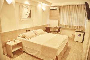 a hotel room with a bed and a television at Miramar Hotel in Balneário Camboriú