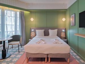 a bedroom with a bed with two dresses on it at Aparthotel AMMI Nice Lafayette in Nice