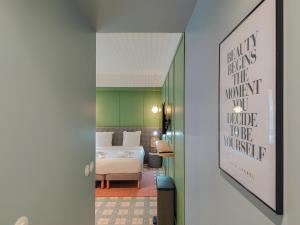 a hallway with a bedroom with a bed and a poster at Aparthotel AMMI Nice Lafayette in Nice