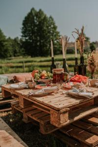 a wooden picnic table with food and wine bottles at Szykidym in Hartowiec