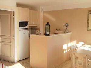 a kitchen with a counter and a white refrigerator at Maison Duplex 8 Pers avec Terrasse, 3 Ch, Parking Gratuit, Animaux Admis, Accès Piscine - FR-1-382-128 in Grospierres