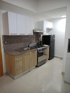 una cucina con armadietti bianchi, piano cottura e frigorifero di Simply the most comfortable place next to Boca Chica beach a Boca Chica