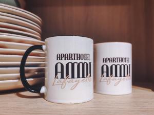 two coffee mugs sitting on top of a table at Aparthotel AMMI Nice Lafayette in Nice