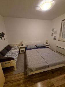 sypialnia z 2 łóżkami i kanapą w obiekcie Apartma JP Terme Čatež w mieście Čatež ob Savi