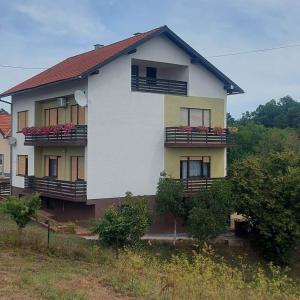 a house with flowers on the balconies of it at Apartman Danny in Slunj