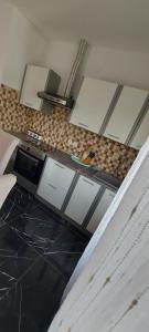 a kitchen with white cabinets and a counter top at Apartman Danny in Slunj