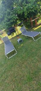 two chairs and a picnic table in the grass at Apartman Danny in Slunj