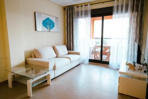 sala de estar con sofá blanco y mesa de cristal en Sol Dénia, en Denia