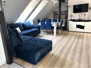 a living room with a blue couch and a table at Apartament CENTRUM in Mrągowo