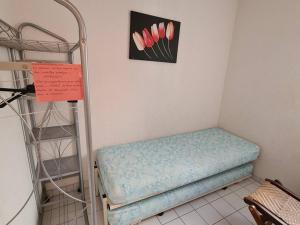 a room with a bed and a shelf with pink flowers at Appartement 2P cabine, 100m plage, terrasse, parking - Argelès-sur-Mer - FR-1-388-94 in Argelès-sur-Mer