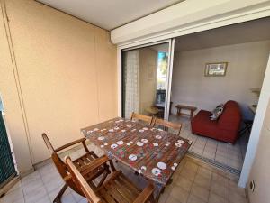 a room with a table and chairs and a couch at Appartement 2P cabine, 100m plage, terrasse, parking - Argelès-sur-Mer - FR-1-388-94 in Argelès-sur-Mer