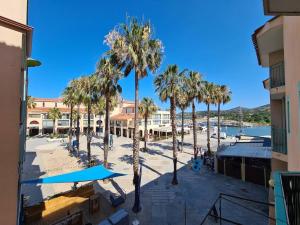 a view of a beach with palm trees and buildings at Appartement 2P cabine, 100m plage, terrasse, parking - Argelès-sur-Mer - FR-1-388-94 in Argelès-sur-Mer