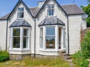 Uma casa branca com três janelas. em Mossdale em Rockcliffe