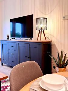 een woonkamer met een tv op een blauw dressoir bij Apartament 25 Rowery, Spacery w Dolinie Baryczy - 5D Apartamenty in Milicz