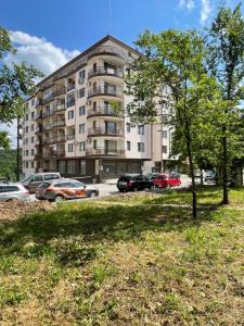 a large building with cars parked in a parking lot at Studio Shevitsa & free Garage in Veliko Tŭrnovo